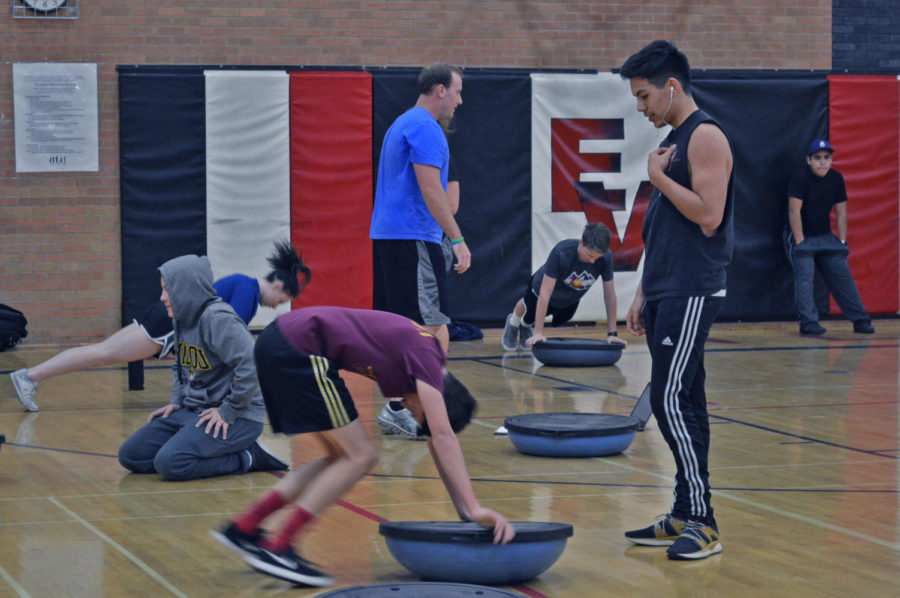 Alexis Dominguez ‘19 does a push up with the BOSU ball while his teammate while Omar Moran ‘20 supports him. They both look out for each other on each exercise.
